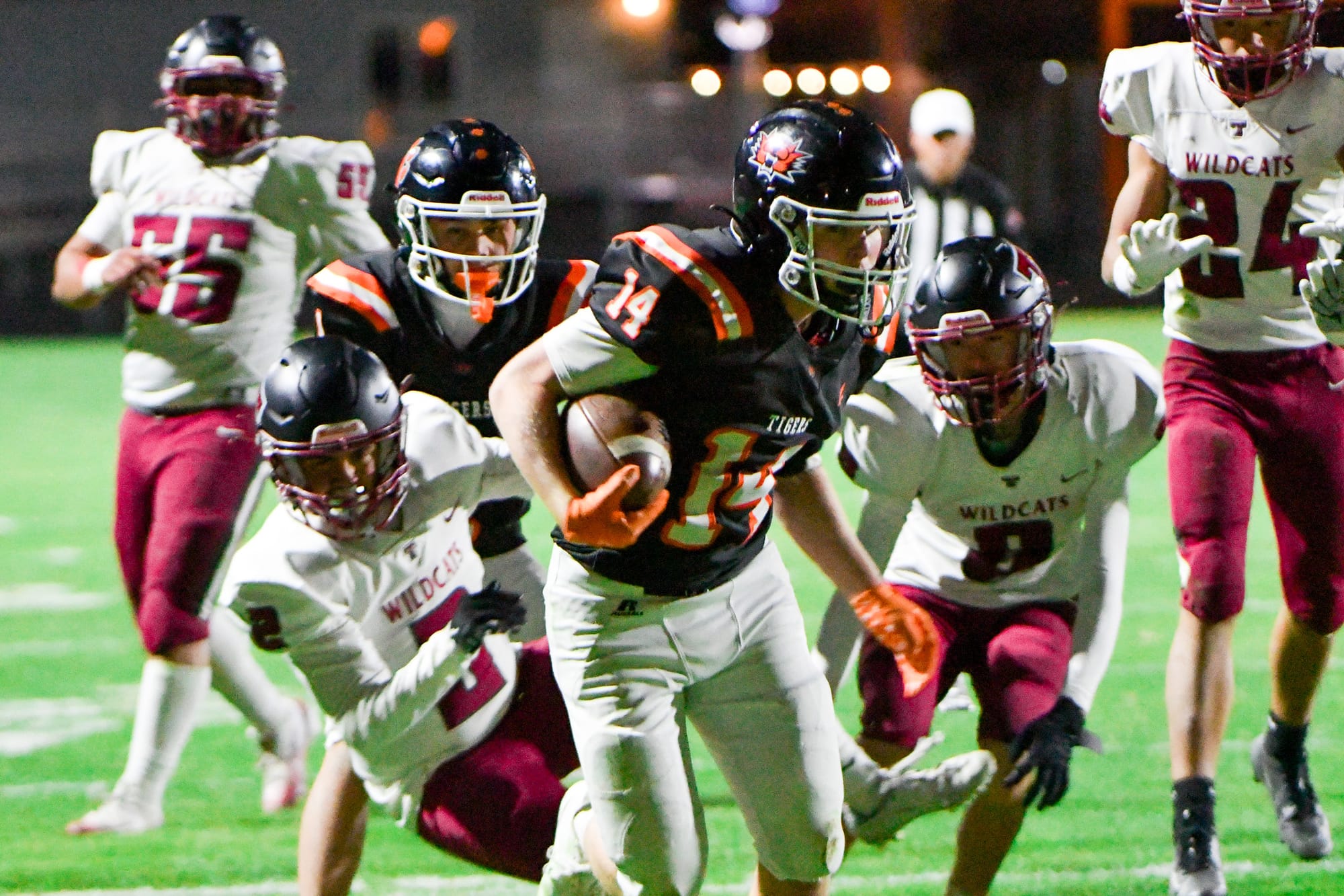 Carson Andrus (14) charges through a pack of Wildcats for one of his two touchdown runs.