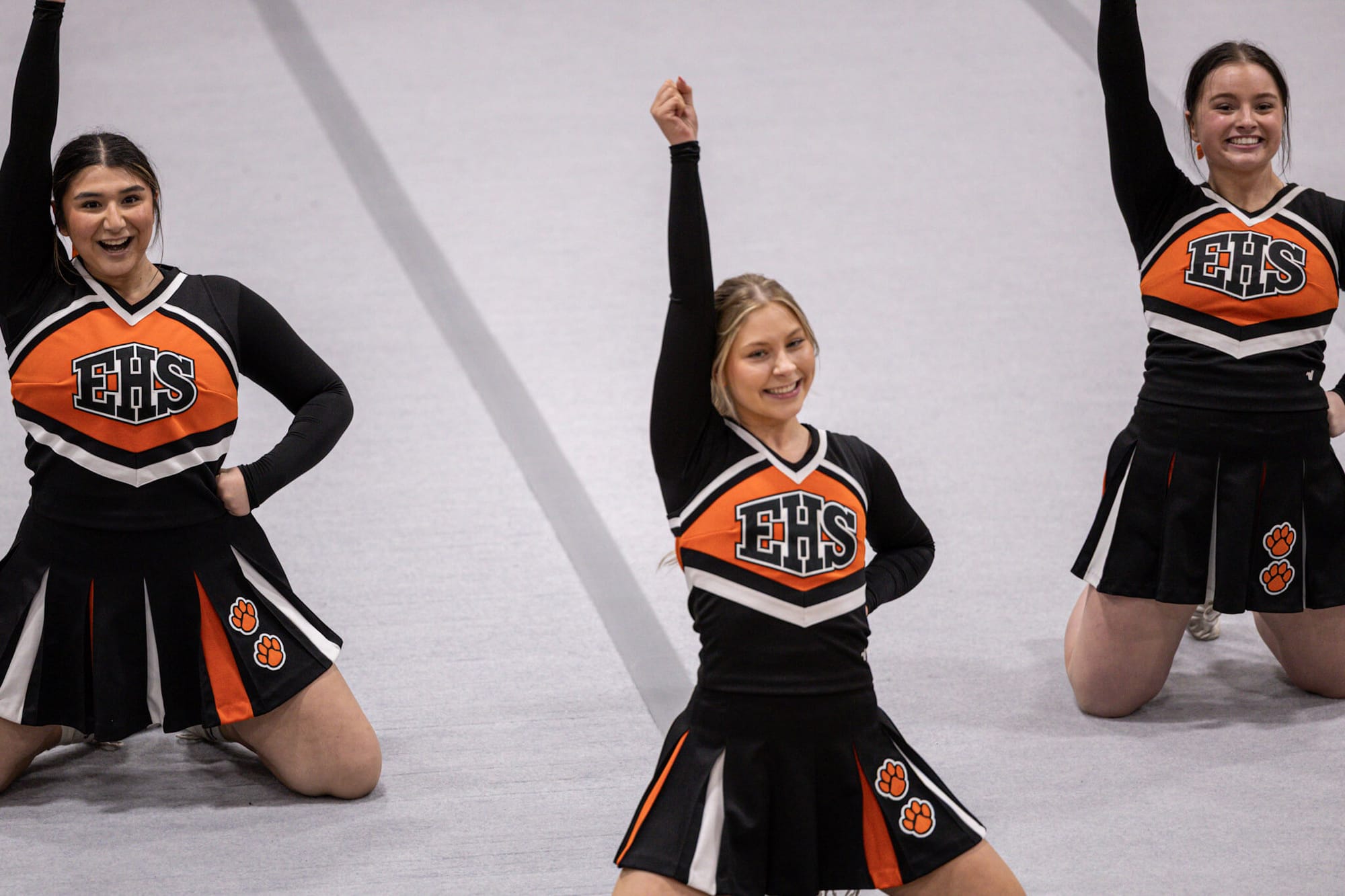 From right to left Madilynn Pruneda Gonzales, Hannah Allen and Payton Canfield cheer from the mat.